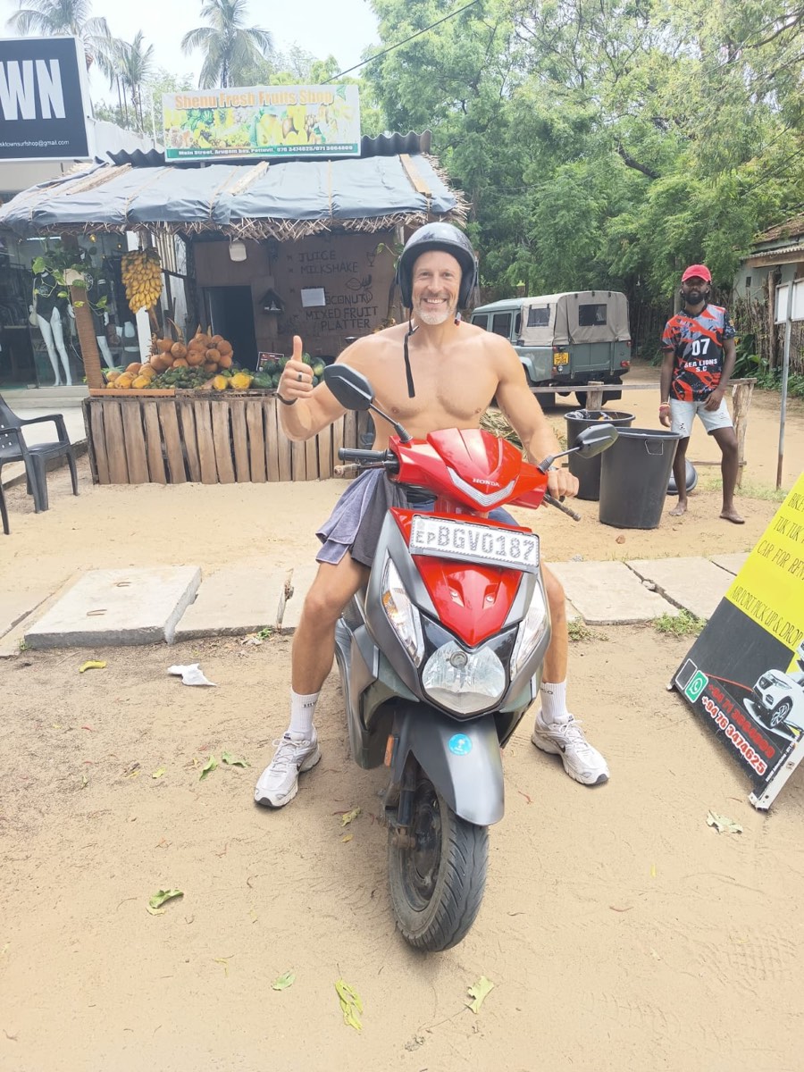 A traveller giving a thumbs-up on an SP rental scooter in Arugam Bay