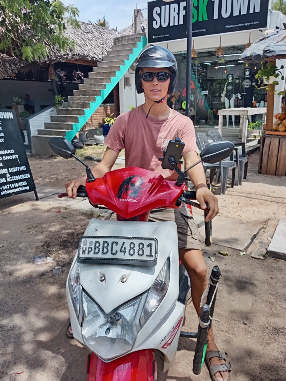 A customer with their SP rental scooter outside the shop in Arugam Bay